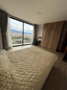 a bedroom with a large bed and a large window at Casa con vista a cuenca in Cuenca