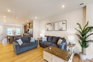 a living room with two couches and a table at The Peninsula --- 22308 Dune Cir 74 in Millsboro