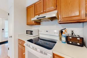 a kitchen with a stove and a microwave at Sea Colony -- 8901 Timberlake in Bethany Beach