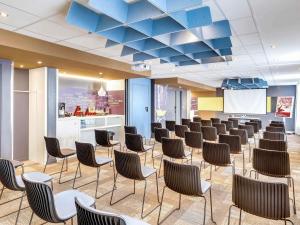 a conference room with chairs and a podium at ibis Paris Coeur d'Orly Airport in Orly