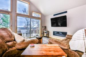 a living room with couches and a tv and a table at A Place To Gather in Tomahawk