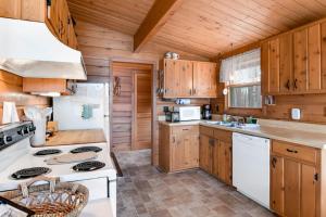 a kitchen with wooden cabinets and a white stove top oven at Lakeview North in Lac du Flambeau +31 photos