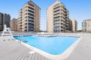 a large swimming pool with two tall apartment buildings at Sea Colony - 709 Brandywine House Rd in Bethany Beach