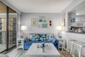 a living room with a blue couch and a kitchen at Sea Colony - 709 Brandywine House Rd in Bethany Beach