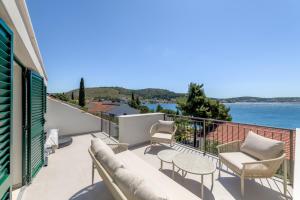 a balcony with furniture and a view of the water at 7 Olives Luxury Suites in Rogoznica