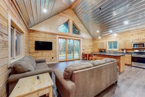 a living room with two couches and a kitchen at Black Bear Cabin in Tomahawk