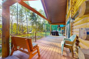 a deck with two chairs and a bench on a cabin at Black Bear Cabin in Tomahawk