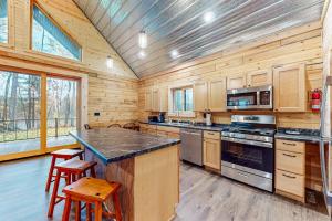 a large kitchen with wooden walls and wooden counters at Black Bear Cabin in Tomahawk +40 photos