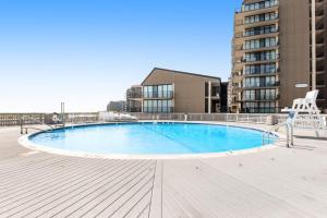 a large swimming pool on a boardwalk with a building at Sea Colony - 2D Brandywine Garden House Rd in Bethany Beach