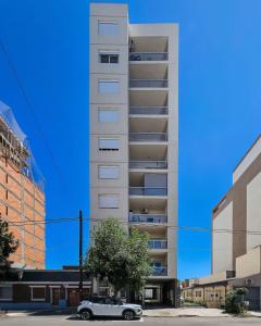 a car parked in front of a tall building at Bienestar Studio in Bahía Blanca