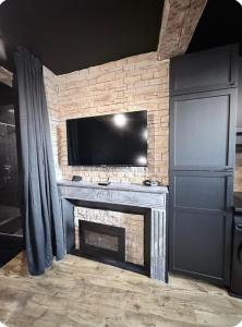 ein Wohnzimmer mit Kamin und Flachbildfernseher in der Unterkunft Loveroom agathoise in Agde + 5 Fotos