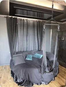 ein Bett mit Baldachin und blauen Kissen in der Unterkunft Loveroom agathoise in Agde