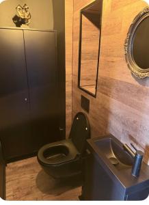 ein Badezimmer mit schwarzer Toilette und Waschbecken in der Unterkunft Loveroom agathoise in Agde