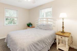 a bedroom with a bed and a lamp and two windows at 112 Loganberry Lane in Rehoboth Beach +17 photos