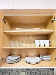 a cabinet with plates and wine glasses and cups at Las Palmas in Biscayne Seaplane Base +32 photos