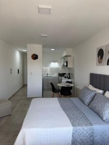 a bedroom with a large bed and a kitchen at Bienestar Studio in Bahía Blanca