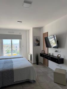 a bedroom with a bed and a flat screen tv at Bienestar Studio in Bahía Blanca