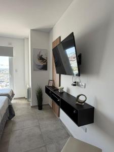 a living room with a television on a wall at Bienestar Studio in Bahía Blanca
