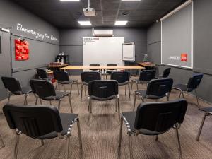 a classroom with chairs and a table and a whiteboard at ibis Portsmouth in Portsmouth