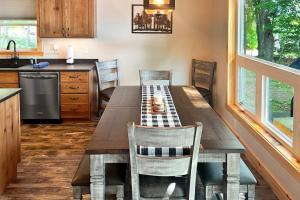 a kitchen with a wooden table with chairs and a sink at Pair-a-Docks Landing in Minocqua +31 photos