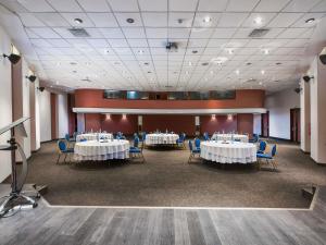 a conference room with tables and chairs and a stage at Sofitel Algiers Hamma Garden in Alger +81 photos