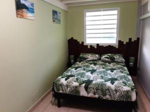 a bedroom with a bed and a window at Ti Kaz en Nou' in Pointe-Noire