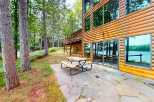 a wooden house with a picnic table in front of it at Pickerel Point Home in Saint Germain