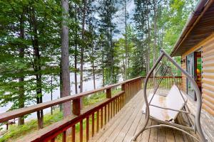 a swing on the deck of a cabin at Pickerel Point Home in Saint Germain
