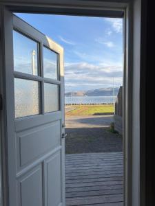 an open door with a view of the water at Krókur Guesthouse in Patreksfjörður +5 photos