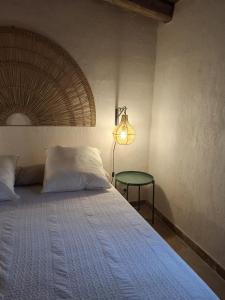 a bedroom with a bed with a lamp and a table at Casa Olea in Sartène
