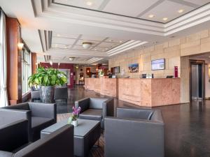 a lobby of a hotel with chairs and a bar at Mercure Hotel Potsdam City in Potsdam