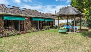 una casa con cenador en el patio en Summer Blue Guesthouse, en Port Elizabeth