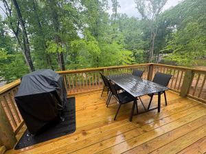 a wooden deck with a table and chairs on it at The Hideaway at Wolf Creek in Nancy