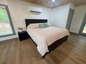 a bedroom with a bed and a wooden floor at The Hideaway at Wolf Creek in Nancy