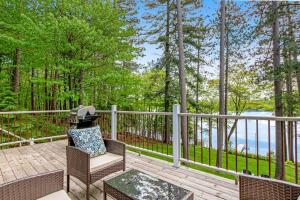 a chair and a table on a deck with trees at Road Lake Escape in Tomahawk