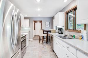 a kitchen with white cabinets and a refrigerator at Road Lake Escape in Tomahawk +32 photos