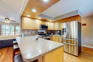 a kitchen with wooden cabinets and a stainless steel refrigerator at Dreams on the Lake in Tomahawk +31 photos