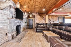 a living room with leather furniture and a fireplace at Timber Lodge Retreat in Rhinelander