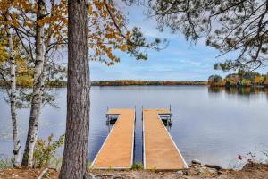 a dock in the middle of a lake with trees at Timber Lodge Retreat in Rhinelander