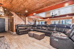 a living room with leather furniture and wooden walls at Timber Lodge Retreat in Rhinelander