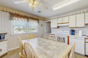 a kitchen with a table and chairs and a ceiling fan at 37534 Lighthouse Rd #202 in Fenwick Island