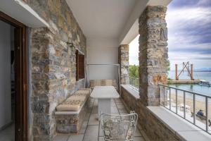 a balcony with a bench and a view of the water at Moutsouna Seaside in Moutsoúna