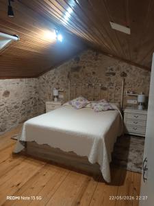a bedroom with a bed and a stone wall at "la Casita" in Boiro +9 photos