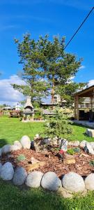 a garden with rocks and a tree in a yard at Pokoje u Janci i Stasia in Poronin