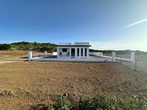 a building on the side of a dirt field at Casa Trankilo in Fontein