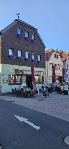 a building with tables and umbrellas on a street at Stadtblick Bischofsheim in Bischofsheim an der Rhön