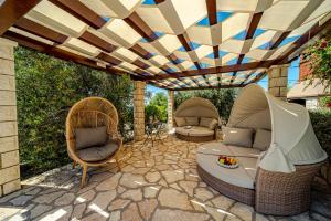 a patio with two chairs and a couch under a pergola at Apartments Separovic in Prizba