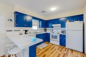 a kitchen with blue cabinets and a white refrigerator at Rehoboth Beach Anna B St in Rehoboth Beach