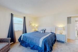 a bedroom with a blue bed and a chair at Rehoboth Beach Anna B St in Rehoboth Beach +10 photos