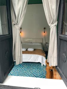 a bedroom with a bed with curtains and a window at La Tozi Hotel in San Cristóbal de Las Casas +29 photos